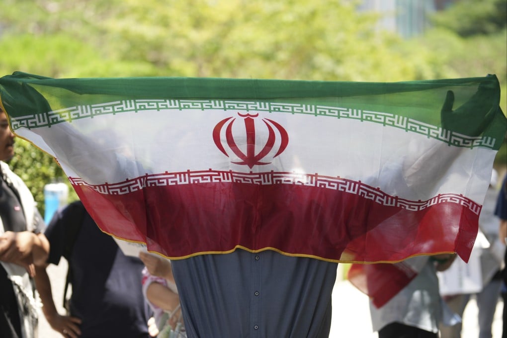 A man holds an Iranian flag during a rally demanding an end to the war between Israel and Iran in Seoul, South Korea on Sunday. Photo: AP