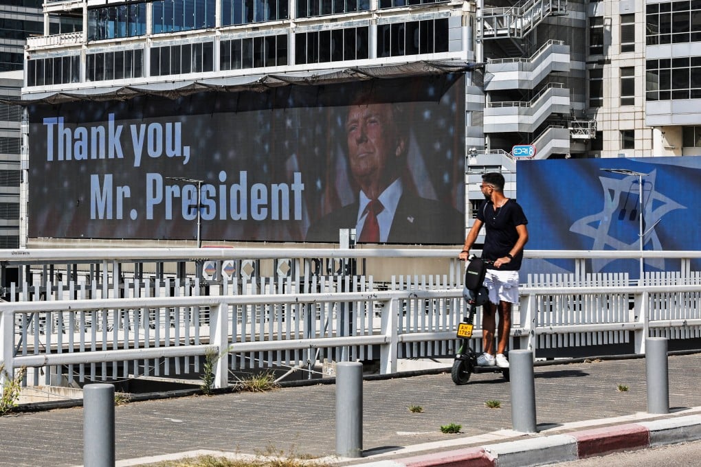 A man on an e-scooter passes a giant billboard, featuring US President Donald Trump, in Tel Aviv, Israel, on Sunday. Photo: Reuters