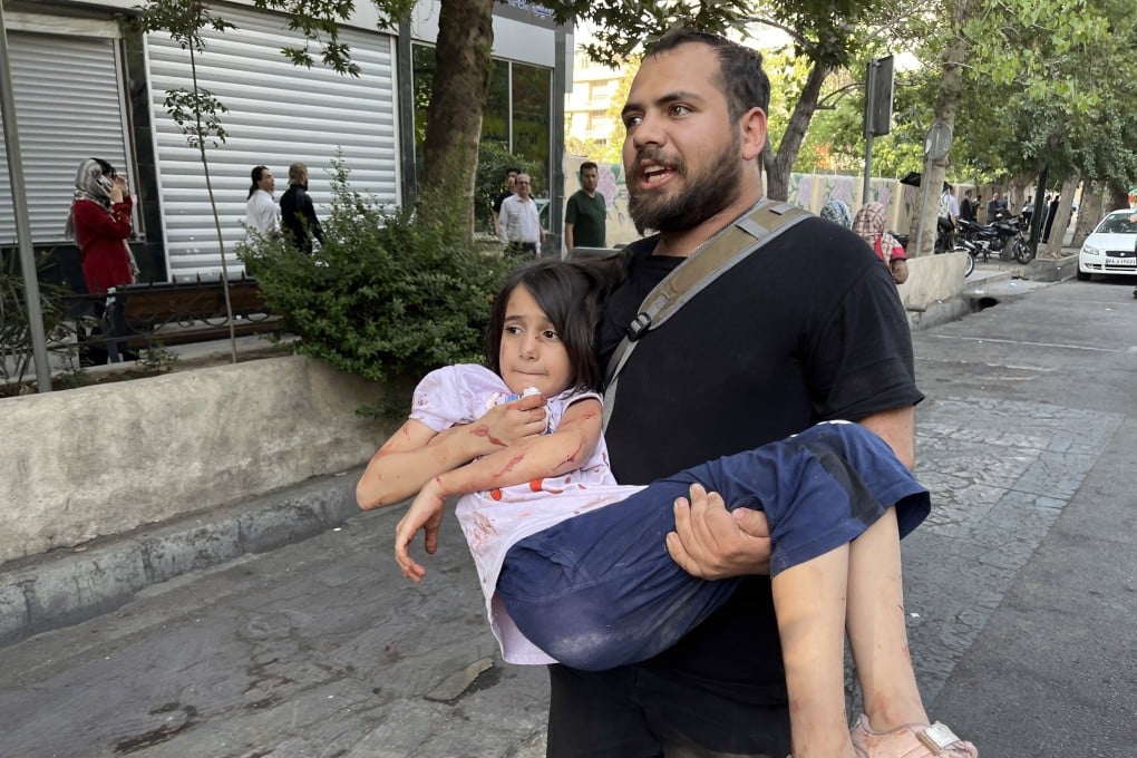 A man carries his wounded child following an Israeli airstrike on Tehran, Iran, on June 15. Photo: EPA-EFE