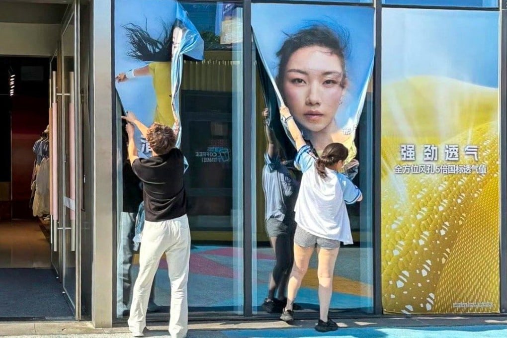 Posters of Chinese actress Nashi are ripped from a mainland store’s window amid the controversy over the fraud she committed to get ahead in her studies. Photo: SCMP