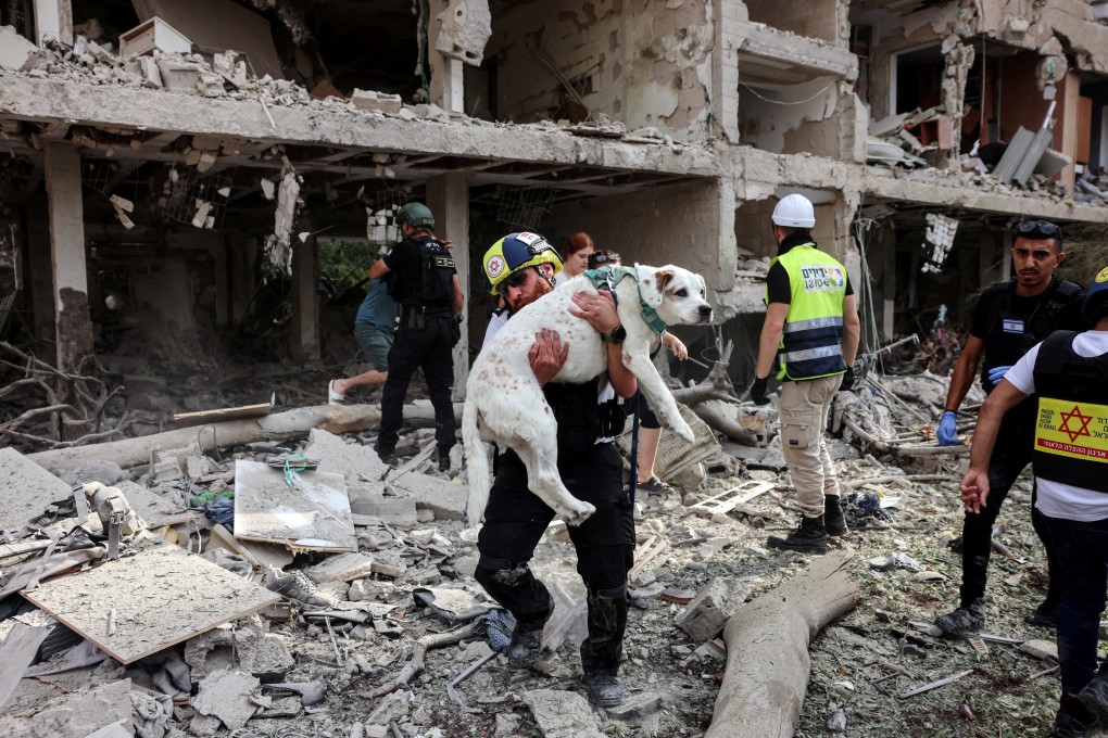 A rescuer carries a dog out of the wreckage after an Iranian missile attack on Tel Aviv in Israel on the weekend. Photo: Reuters