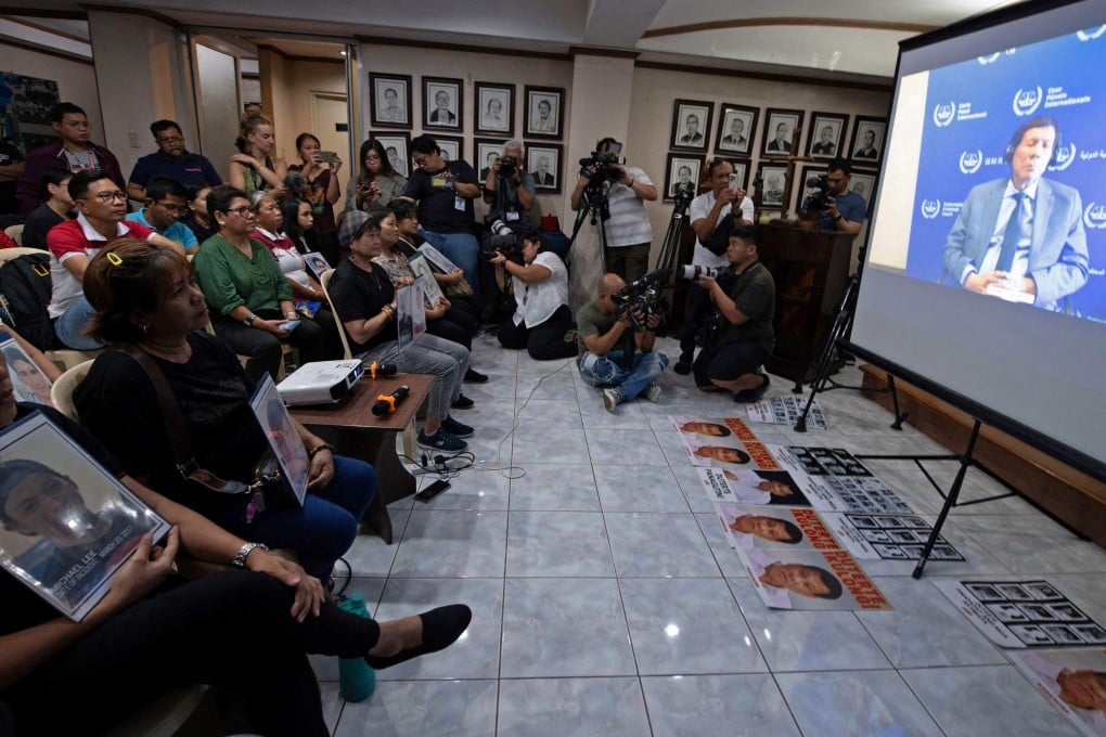 Families holding portraits of victims of former Philippines president Rodrigo Duterte’s drug war watch a live stream of Duterte’s first appearance at the International Criminal Court on March 14. Photo: AFP