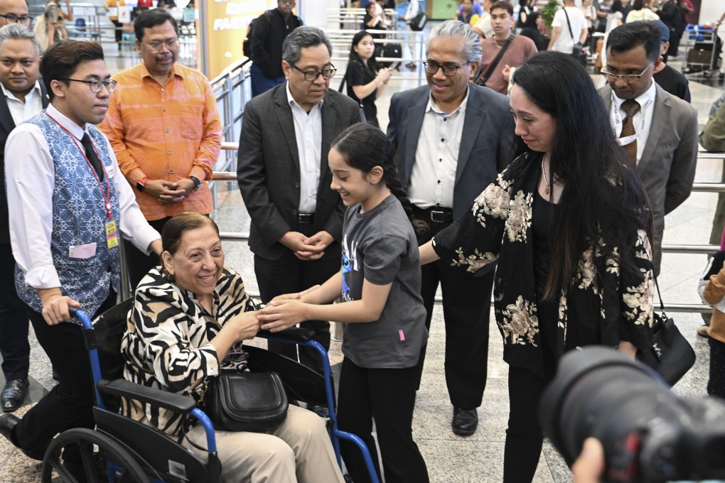 Malaysia’s Ambassador to Iran Khairi Omar (back row, centre right) and foreign ministry official Ahmad Rozian Abd Ghani (centre left) at Kuala Lumpur International Airport late on Sunday with other evacuees from the conflict-hit country. Photo: Malaysian Ministry of Foreign Affairs / EPA-EFE