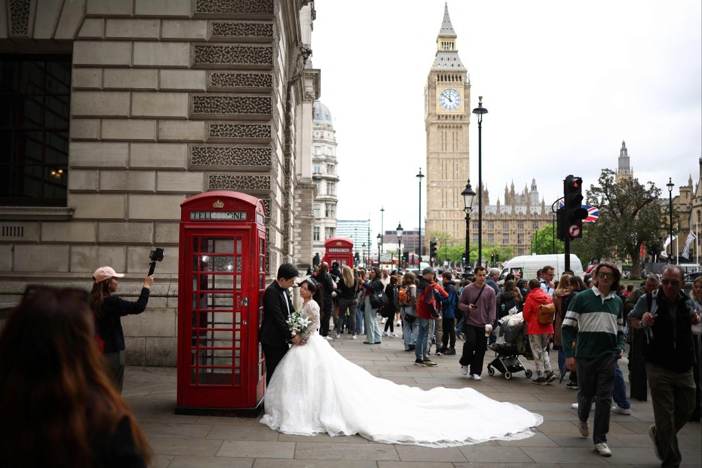 Newlyweds pose next to a red telephone booth in London on May 24. Dating today is not always about searching for a spouse, but for a compatible person to share life with. Photo: AFP