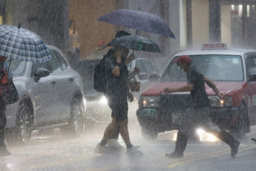 Pedestrians attempt to shelter from the rain in Sheung Wan. Photo: Jonathan Wong