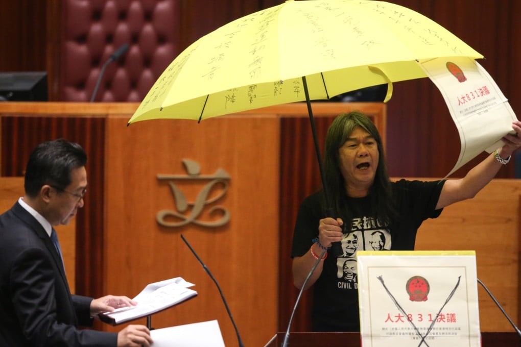 Leung Kwok-hung protests during the oath-taking session while Legco Secretary General Kenneth Chan Wei-on looks on in October . 2016. Photo: Sam Tsang