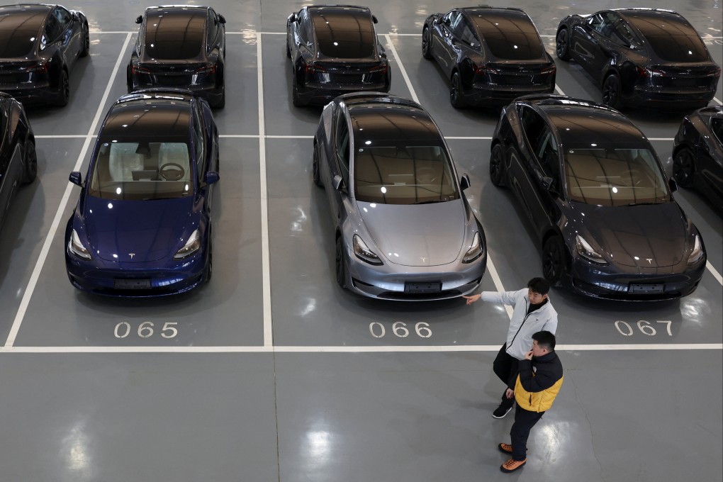 People walk past Tesla electric vehicles at the carmaker’s delivery centre in Beijing in January. Unique EV features like regenerative braking systems can induce motion sickness, according to researchers. Photo: Reuters