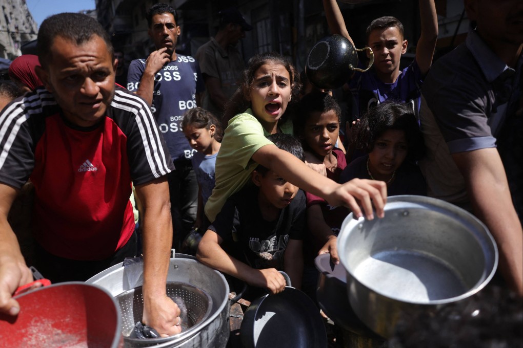 Palestinians line up to receive a hot meal at a food distribution point in Gaza City on Friday. Photo: AFP