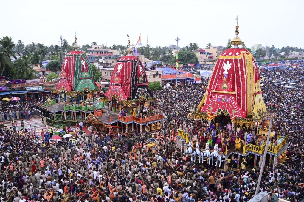 Hindu devotees walk in a procession accompanying three large chariots housing deities, in Puri, India, on Saturday. Photo: AP