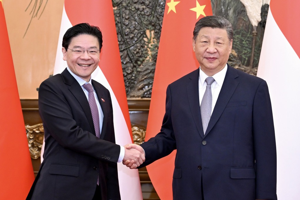Chinese President Xi Jinping (right) and Singaporean Prime Minister Lawrence Wong pose for a handshake during an official visit to China, at the Great Hall of the People in Beijing, June 24, 2025. Photo: EPA