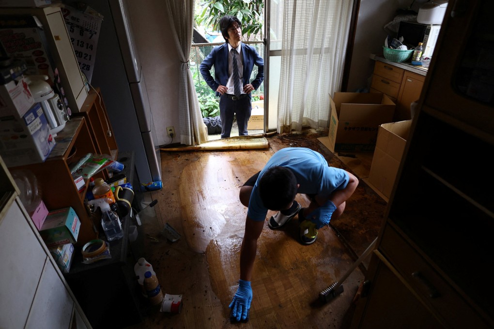 Akira Ookuma, founder of real estate company Happy Planning, looks on while a worker cleans the floor of a house in Ichikawa, Japan, classified as a “jiko bukken”. Photo: Reuters