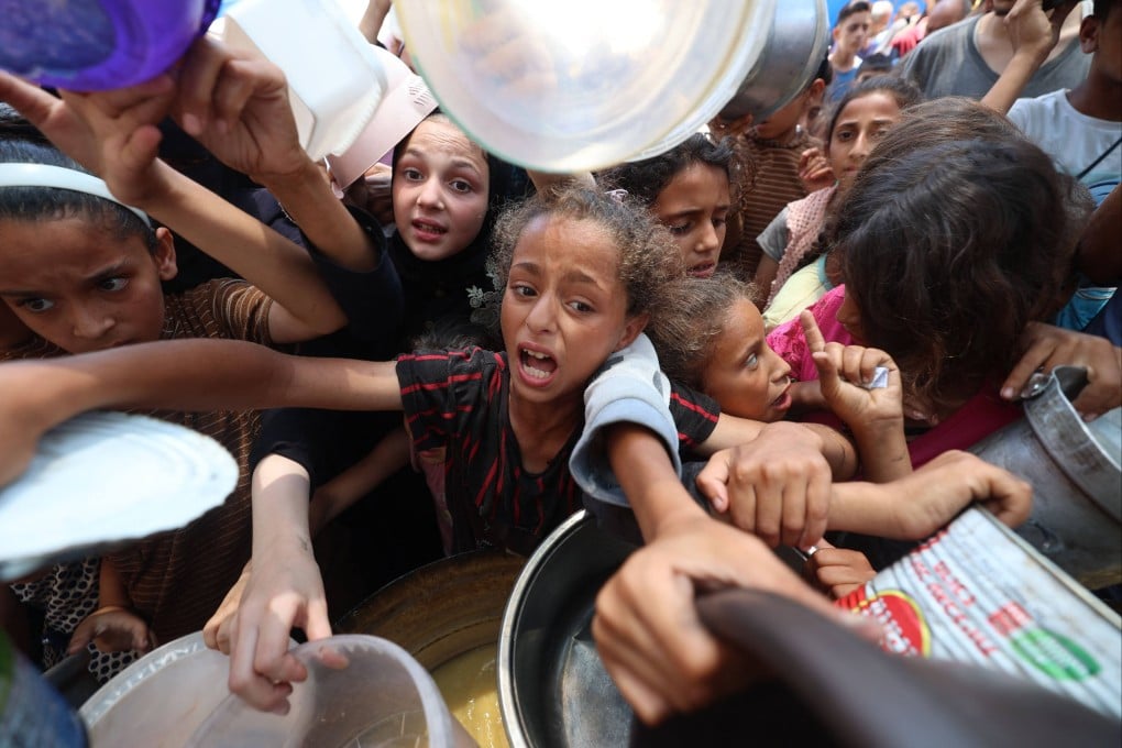 Palestinian children line up to receive a hot meal at a food distribution point in Nuseirat on Monday. Photo: AFP