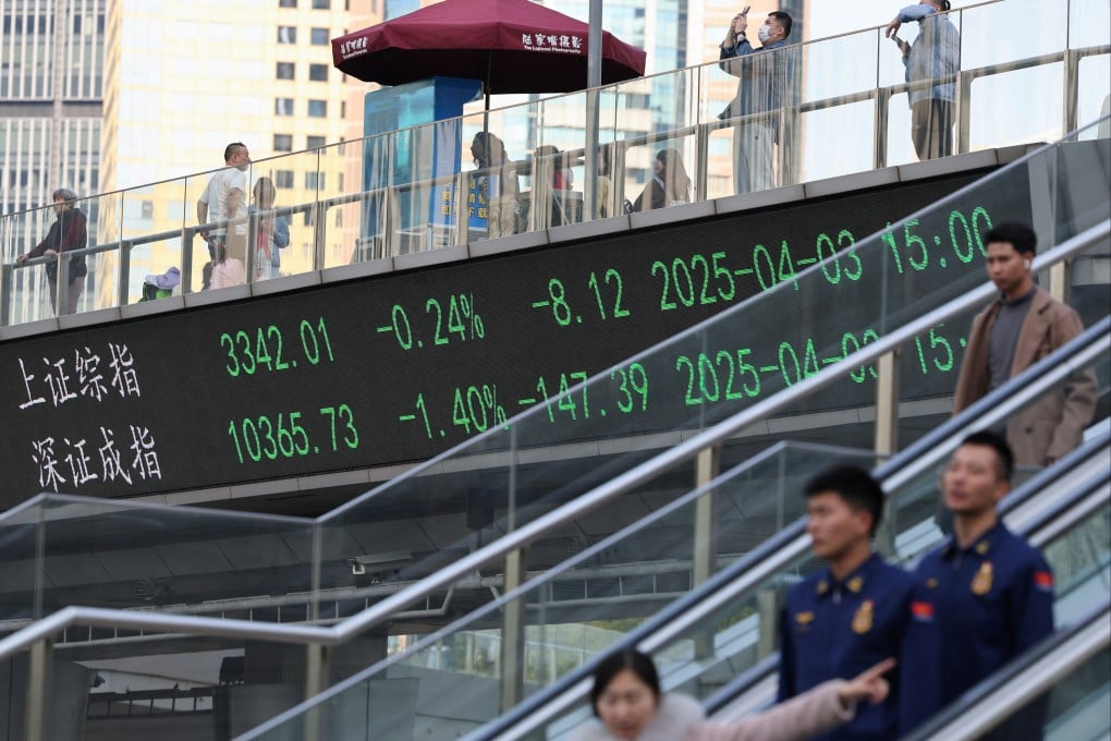 An electronic board showing stock data as people walk on a pedestrian bridge at the Lujiazui financial district in Shanghai. Photo: Reuters