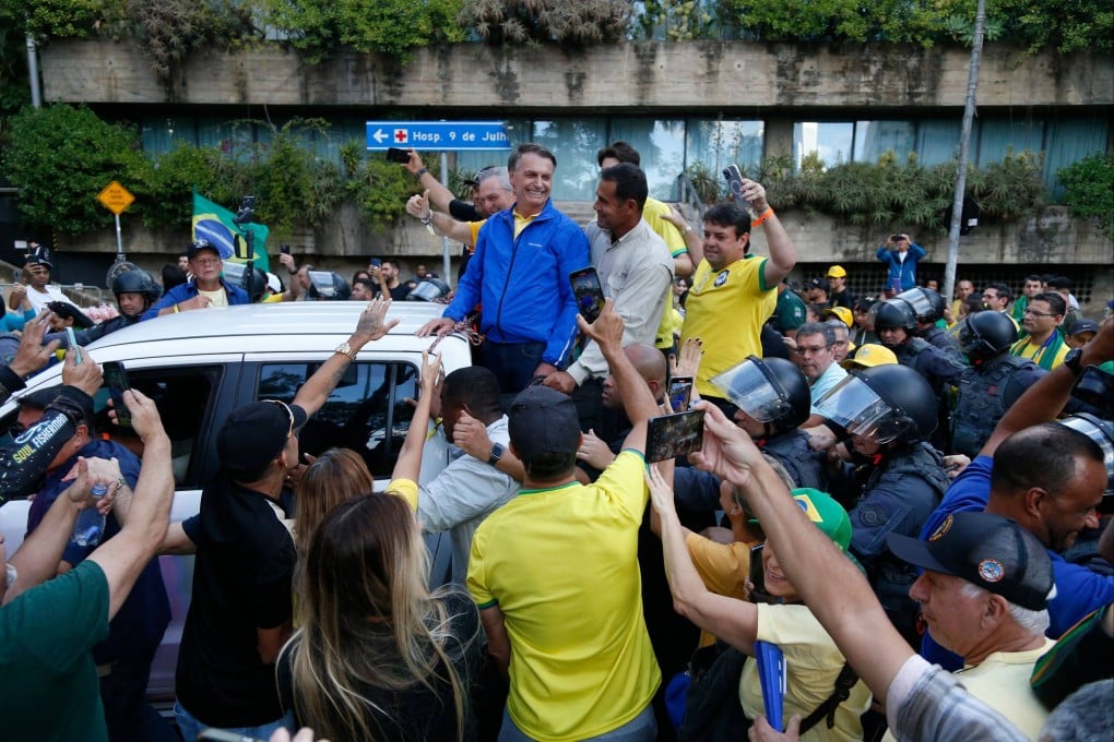 Brazil’s former president Jair Bolsonaro surrounded by supporters. Photo: AFP
