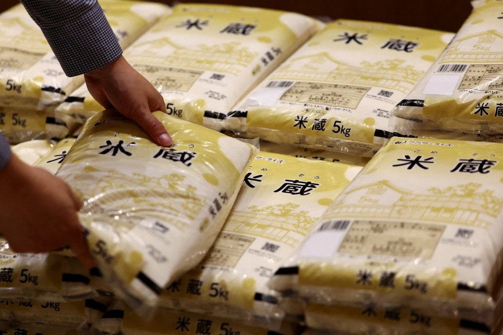 A shopper at a grocery store in Tokyo buys rice that was released from government stockpiles in May. Photo: Reuters
