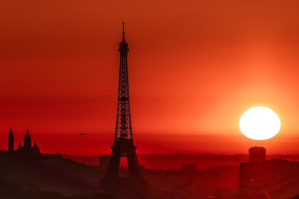 The sun rises by the Eiffel Tower in Paris on Tuesday. Photo: AFP