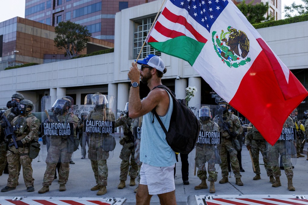 A protester carries US and Mexican flags while demonstrating in front of the California National Guard outside the Federal Building in Los Angeles on June 12. Photo: TNS