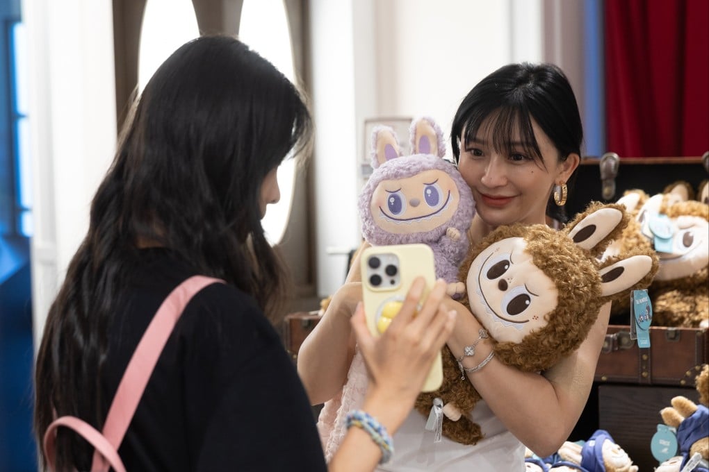 A person holds up Labubu dolls in a store during a press tour to Pop Land, a theme park opened by Chinese toy company Pop Mart, in Beijing, China, on June 2. Photo: EPA-EFE