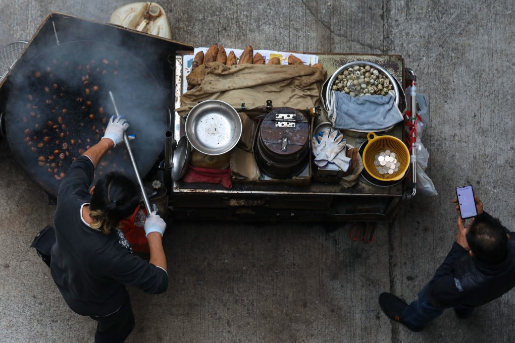 A hawker roasts chestnuts on his food cart in Tuen Mun. Photo: Xiaomei Chen