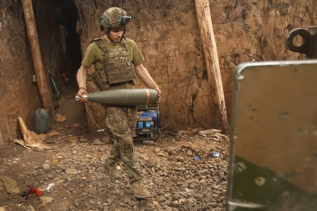 A Ukrainian serviceman carrying an artillery shell. Photo: Reuters
