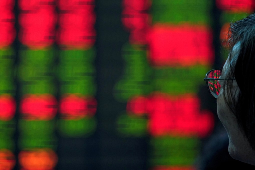 An investor looks stock prices inside a brokerage in Shanghai. Photo: Reuters