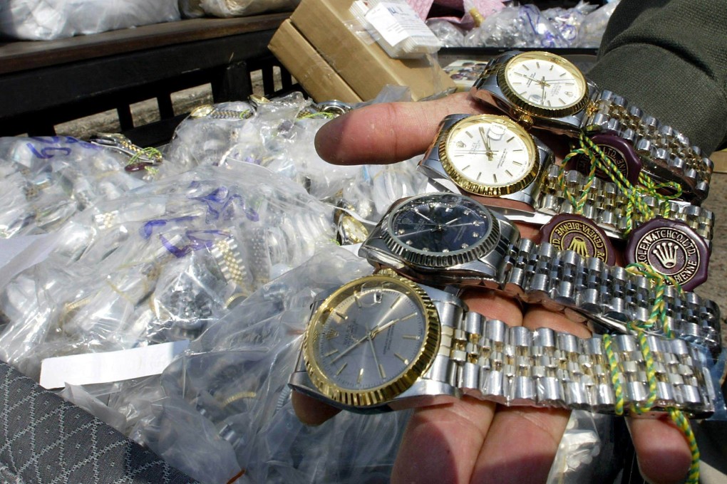A Thai customs officer shows confiscated counterfeit Rolex watches in Bangkok. Photo: AFP