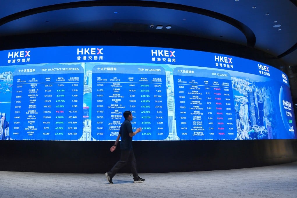 A man walks past an electronic display board at the Hong Kong Stock Exchange in Central. Photo: Xinhua