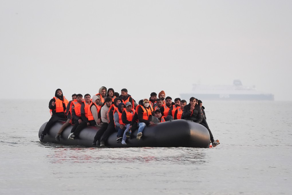 A group of people thought to be migrants on board a small boat leave a beach in France in May, attempting to reach the UK. Photo: dpa