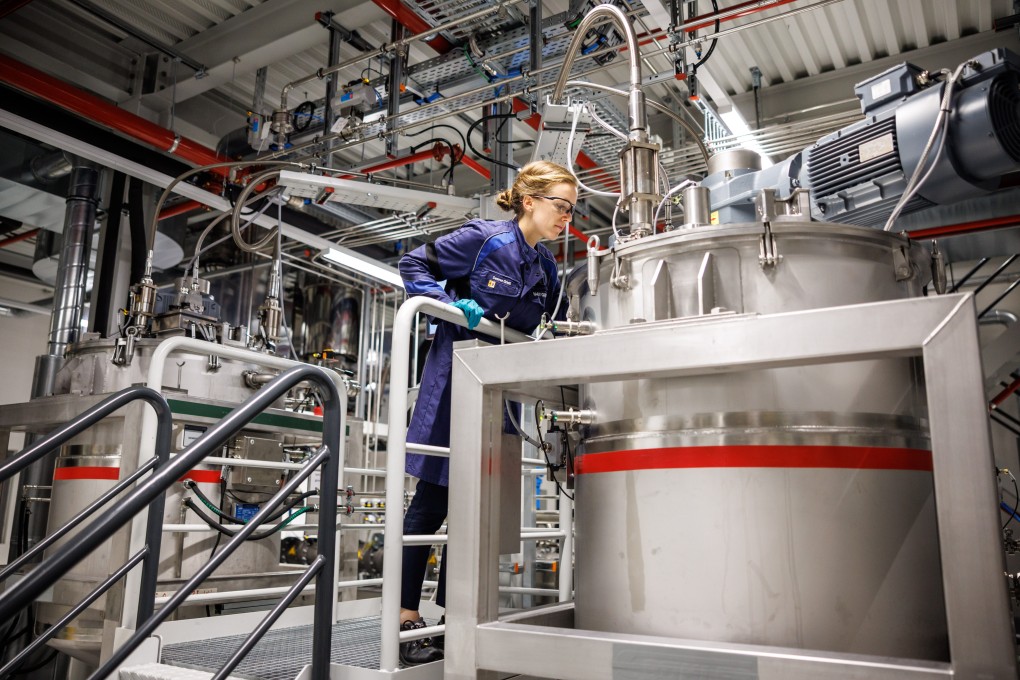 A BMW worker stands between two mixing containers for battery paste during a factory tour. German firms are hoping that a rising manufacturing PMI reading will bode well for business. Photo: dpa/Getty Images