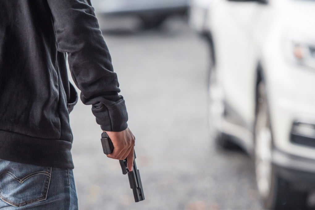 A man holds a gun in a car park. A series of gun attacks in the past few weeks have made Malaysians jittery. Photo: Shutterstock
