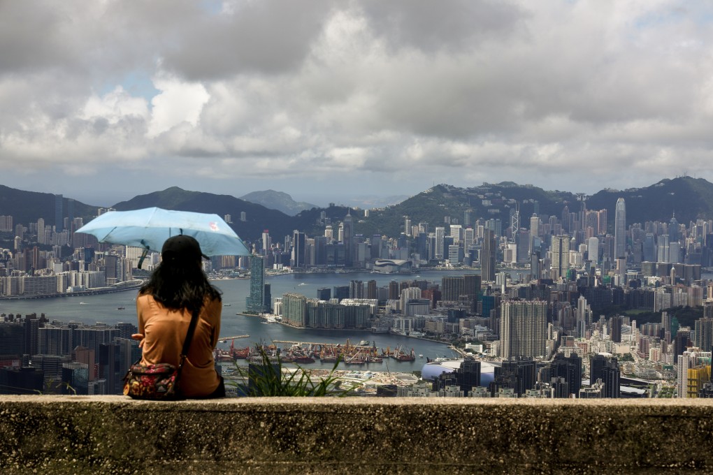 A woman stays under the shade of an umbrella at Kowloon Peak, or Fei Ngo Shan, on June 21. The world today faces many challenges, including climate change and pollution. Photo: Dickson Lee