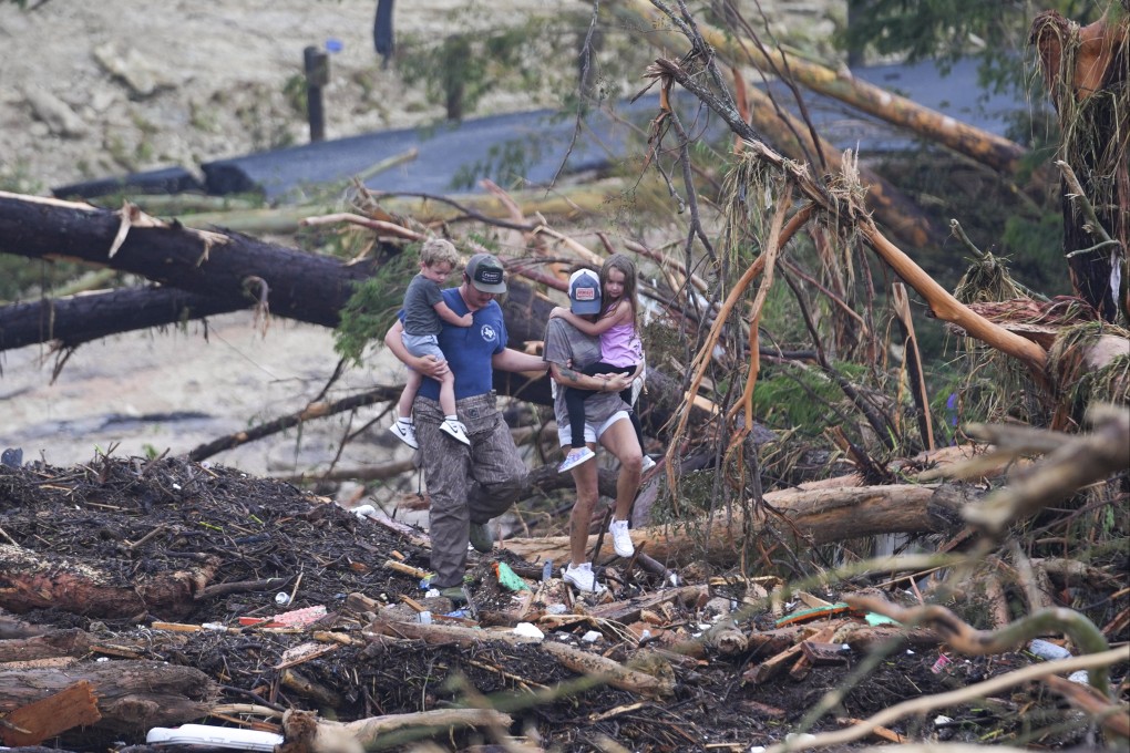 People climb over debris on a bridge atop the Guadalupe River after a flash flood swept through the area on Saturday. Photo: AP