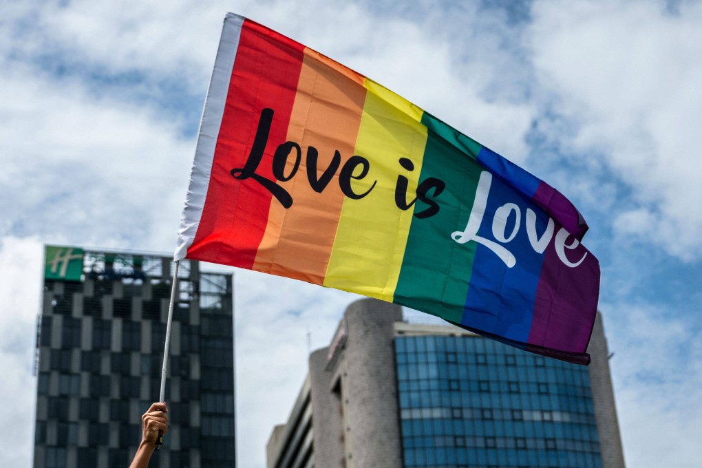 A member of the LGBTQ community holds a rainbow flag while taking part in a pride parade in Bangkok. Photo: AFP