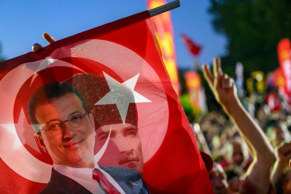 A supporter holds a flag of Istanbul’s detained Mayor Ekrem Imamoglu and the First President of the Republic of Turkey Mustafa Kemal Ataturk during a rally protesting the 100th day of his detention, in Sarachane Square, Istanbul, on Tuesday. Photo: AFP