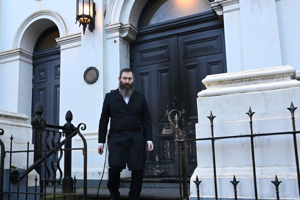 Rabbi Dovid Gutnick stands outside the damaged exterior of the East Melbourne Hebrew Congregation in Melbourne. Photo: AAP/dpa