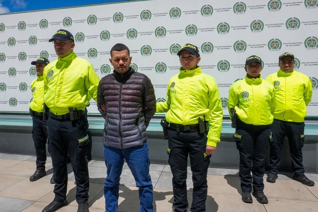 Police officers stand next to Elder Jose Arteaga Hernandez in Bogota on Saturday after he was detained. Photo: Colombian Police via Reuters