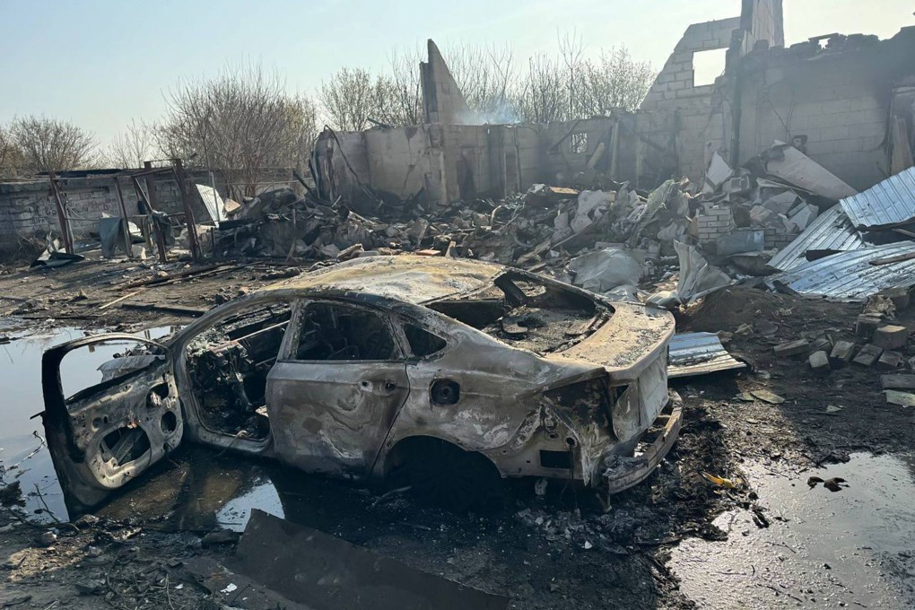 A burnt car next to damaged buildings following a drone attack in Dnipro on March 29. Photo: Dnipropetrovsk Regional Military Administration/AFP