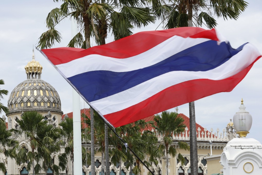 A protester waves Thailand’s national flag outside Government House in Bangkok last month during a rally calling for the resignation of the now-suspended prime minister, Paetongtarn Shinawatra. Photo: EPA