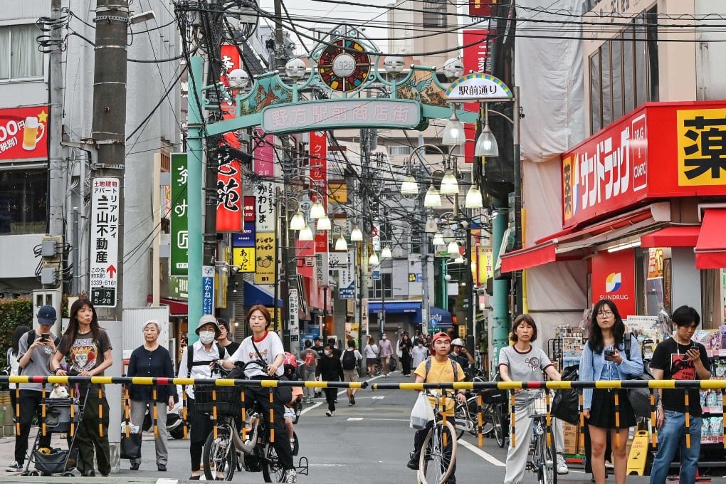 People wait at a level crossing along a shopping street in the Nakano ward of Tokyo. Real wages declined 2.9 per cent from a year earlier in May, Japan’s labour ministry reported on Monday. Photo: AFP
