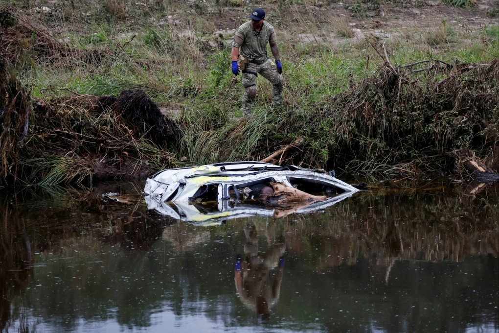 One of many rescuers continues the grim search for people swept away by torrents of water. Photo: Reuters