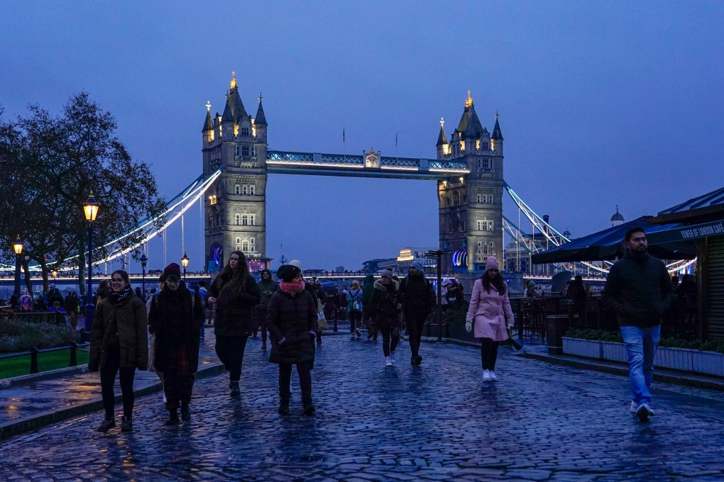 People walk outside the Tower of London as the Tower Bridge stands on the river Thames. Photo: AP
