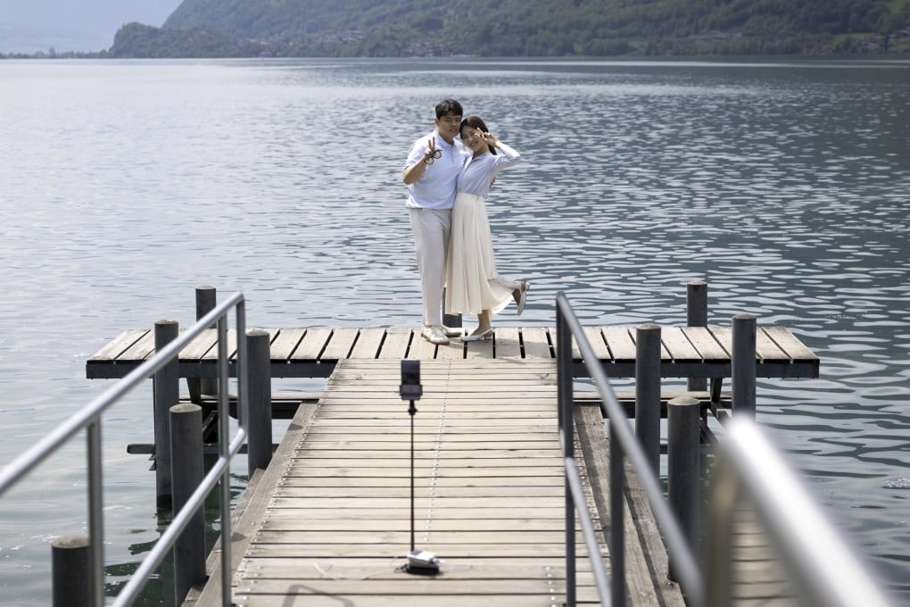 Korean visitors take pictures on the pier at Lake Brienz in Iseltwald, Switzerland, on May 21, 2023. The lakeside dock has seen an influx of tourists since featuring in the hit South Korean Netflix series Crash Landing On You. Photo: AP