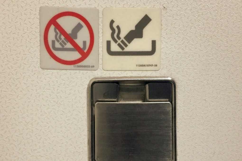 Yes, here is an ashtray but do not use it. Competing notices send mixed messages in an aeroplane lavatory. Photo: Shutterstock