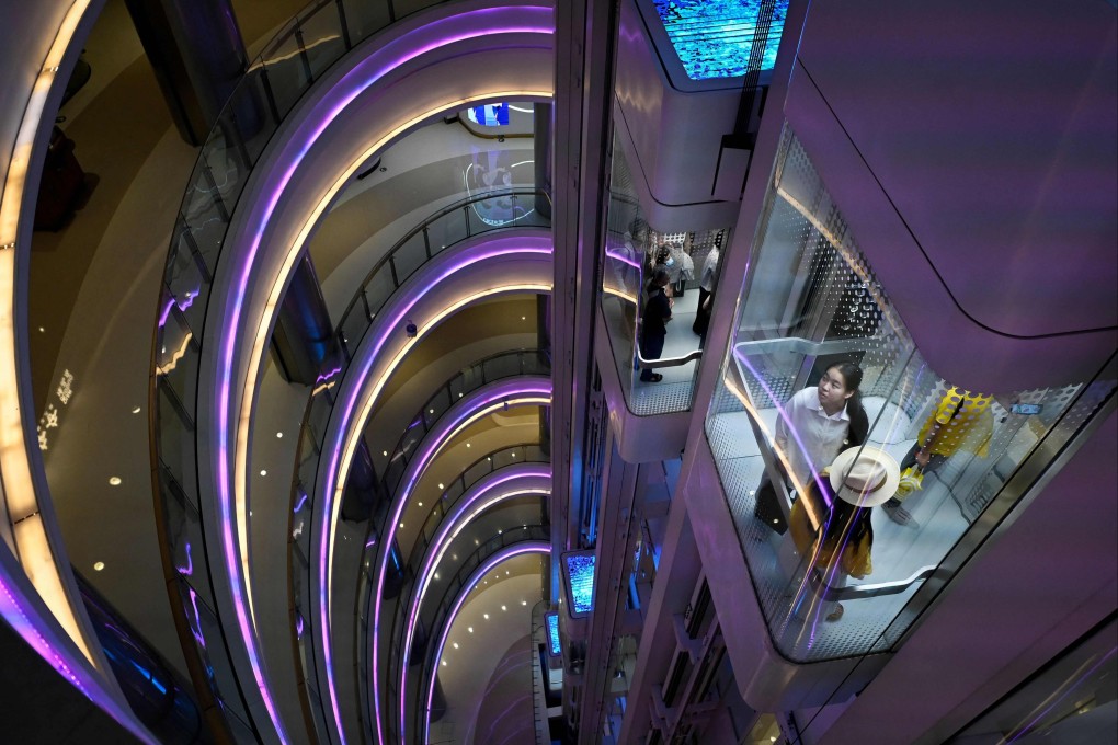People take the lifts at a shopping centre in Beijing’s business district on July 10. Amid a volatile global economic environment, Beijing must move quickly to fortify the domestic economy. Photo: AFP