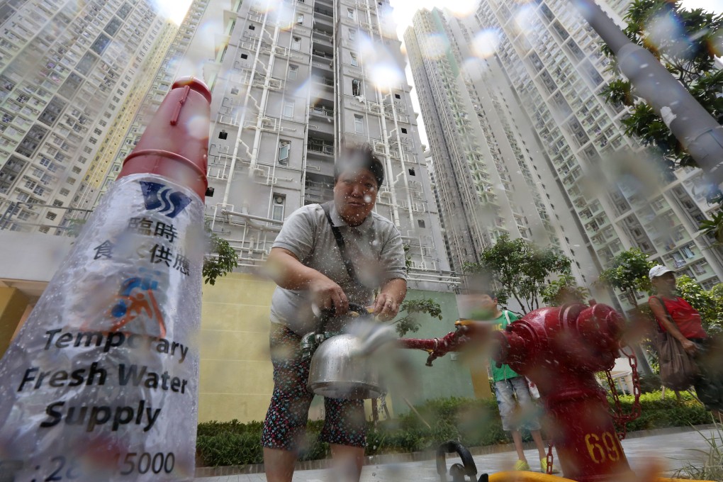 A resident of Kai Tak’s Kai Ching Estate stocks up on water from a temporary tap on July 11, 2015, as excessive amounts of lead were found in fresh water samples from the public housing complex. File photo: Felix Wong