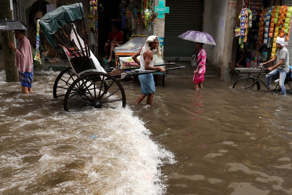 People make their way through a waterlogged street during heavy rain in Kolkata, India, on July Tuesday. Photo: EPA