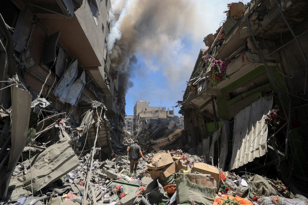 Smoke rises as a Palestinian man inspects the site of Israeli strikes on buildings at Gaza’s Old City market. Photo: Reuters