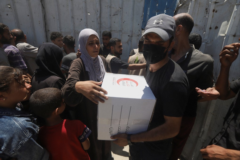 Palestinians receive aid distributed by the Emirates Red Crescent in Gaza City on June 26. Photo: Reuters