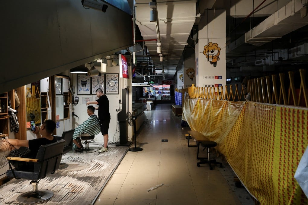 A barber cuts a customer’s hair in a partially closed shopping centre in Shanghai on Thursday. Photo: Reuters