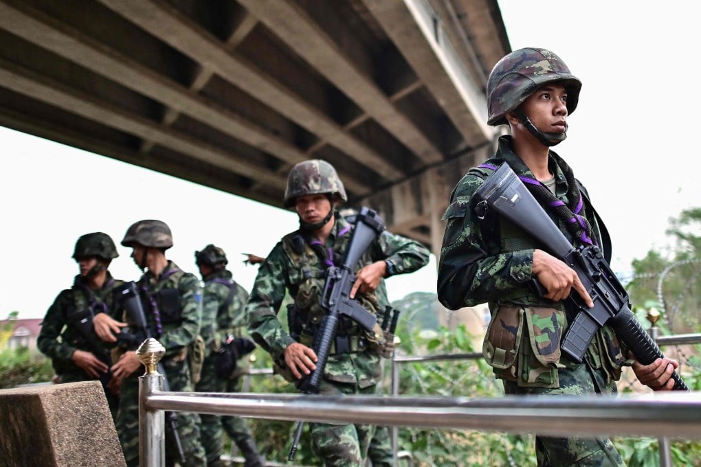 Thai soldiers stand guard overlooking the Moei river on the Thai side near the Tak border checkpoint in April 2024. More than 500 civilians and soldiers fled conflict in Myanmar and crossed into Thailand on Saturday.